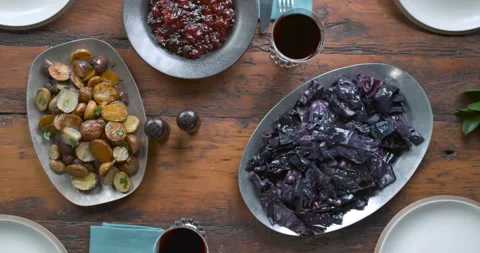 Thanksgiving table with cabbage, potatoes, cranberry sauce, glasses of wine, pea Stock Footage 199458722