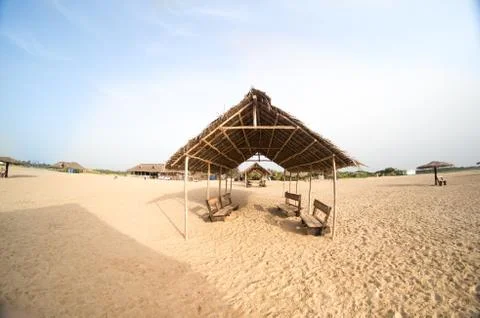Thatch hut on a beach with shadows Stock Photos