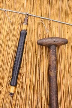 Thatch tools in front of a newly thatched roof Stock Photos