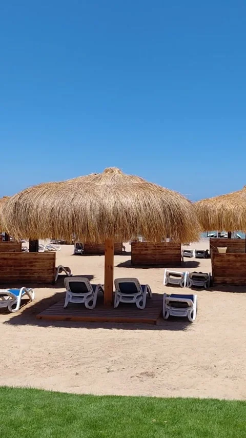 Thatched beach umbrellas and sunbeds on sandy resort in Sahl Hasheesh Egypt. Stock Footage 337532084