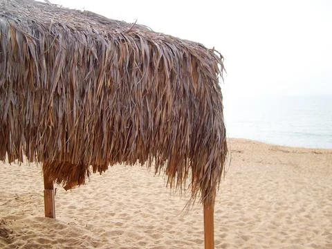 Thatched canopy on the empty sea beach Stock Photos