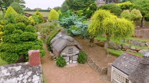 Thatched cottage model at Godshill model village, Isle of Wight as camera rises Stock Footage 340140421