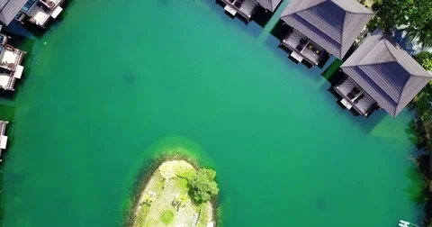 Thatched over water pavilions ringing a still green lagoon Видео 71297351