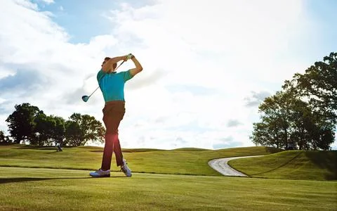 Thats a first class follow through. a man practicing his swing on the golf Stock Photos