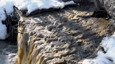 Thawed, dirty water with garbage cascades into the reservoir on a spring day Video stock 149444738