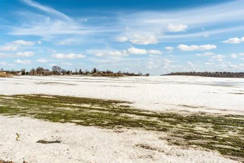 Thawed patch on the field, snowy outdoor soccer field in spring low season Stock Photos