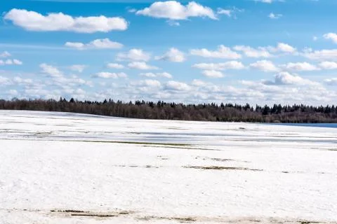 Thawed patch on the field, snowy outdoor soccer field in spring low season Stock Photos