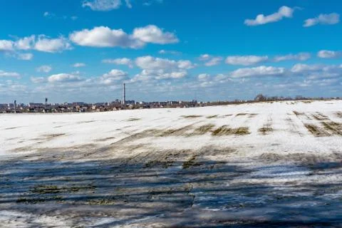 Thawed patch on the field, snowy outdoor soccer field in spring low season Stock Photos