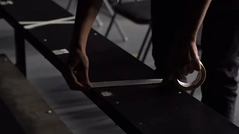 Theater worker marking seats with a warning tape before the performance Stock Footage 139758409