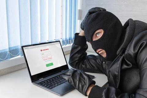 Theft of personal data. Hacking site. A bandit in the office picks up a pas.. Stock Photos