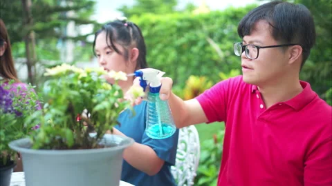 On their day off, Three siblings help water and plant flowers Stock Footage 295992465