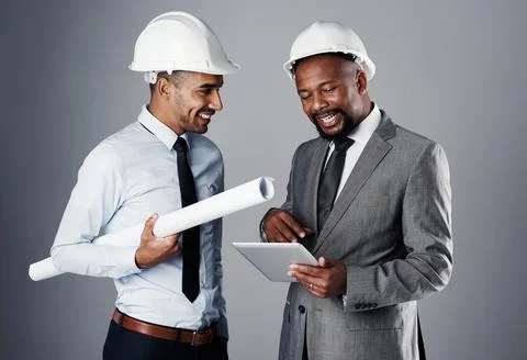 Their partnership is built on a solid foundation. two civil engineers discussing Stock Photos