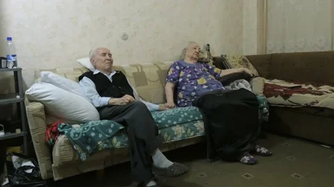 In their room, an elderly man and woman are sitting on the couch. Vídeos de archivo 154983440