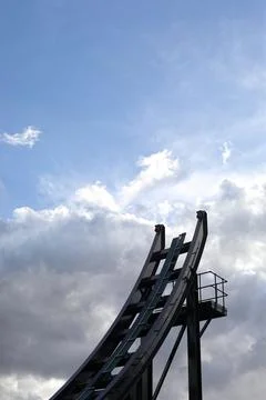 Theme park rollercoaster ride and blue cloudy sky Stock Photos