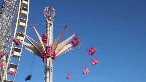 Theme Park turning next to a giant Ferris wheel Stock Footage 142076291