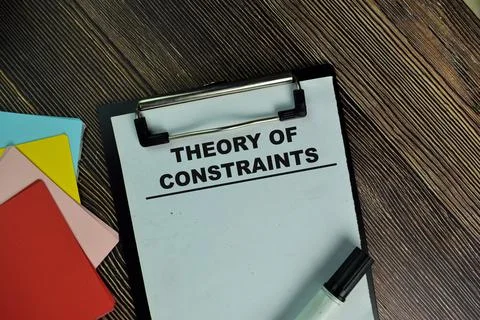 Theory Of Constraints write on a paperwork isolated on Wooden Table. Foto stock