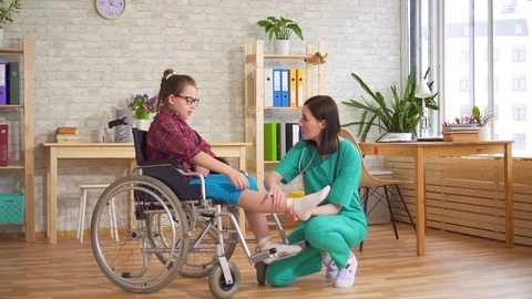 Therapist and a child in a wheelchair in the hospital Stock Footage