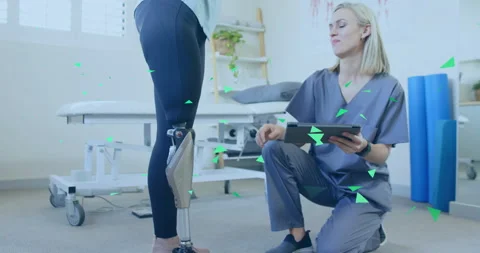 Therapist kneeling with tablet checking notes and aligning knee joint, testing Stock Footage 315483450