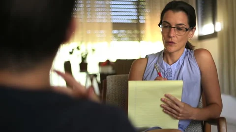 Therapist listening and taking notes at a session Stock Footage 52436663