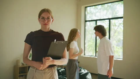 A therapist looks directly at the camera with a troubled expression, while Stock Footage 345011726
