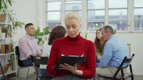 Therapist making notes and smiling at camera Stock Footage 142292433