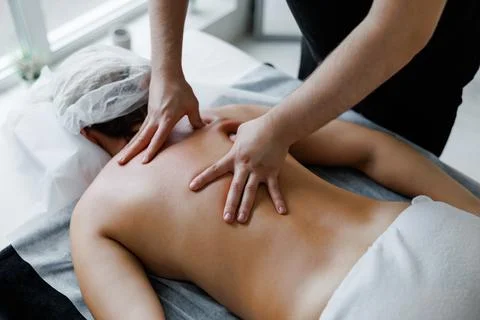 Therapist performing deep tissue back massage on woman Stock Photos
