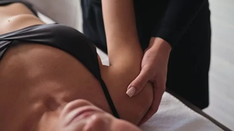 A therapist performs a manual therapy technique on a patient lying face up on a Видео 344380107