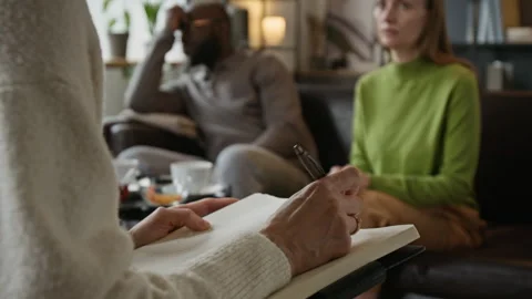 Therapist Taking Notes during Counseling Session with Diverse Couple Stock Footage 337638230