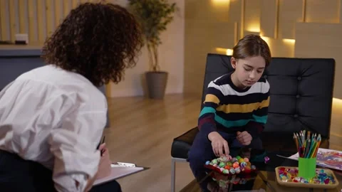 Therapist using colored balls to test kid patient Видео 190982741