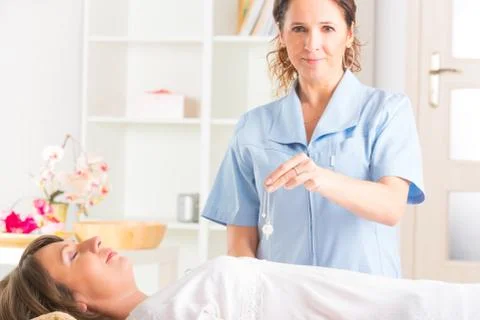 Therapist using pendulum Stock Photos