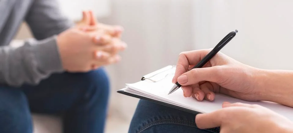 Therapist writing notes during rehab session with patient Stock Photos