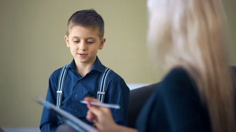 Therapy session classroom with boy listening the woman psychologist speech 動画素材 73574204