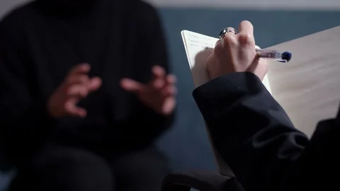 Therapy session: psycologist takes notes during session Stock Footage 85808141