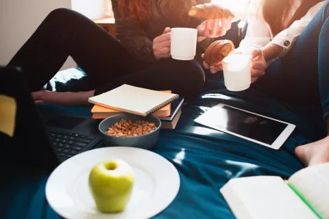 There is an apple, croissant, nuts, tablet pc and notebooks close-up. Two red Stock Photos