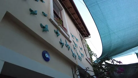 There are evil eye beads and bird figures on the wall. Stock Footage 219963065