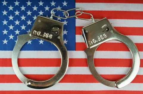 There are handcuffs on the US flag. Stock Photos
