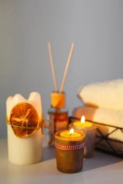 There are lighted aromatic candles on the table, towels for procedures lie. Stock Photos