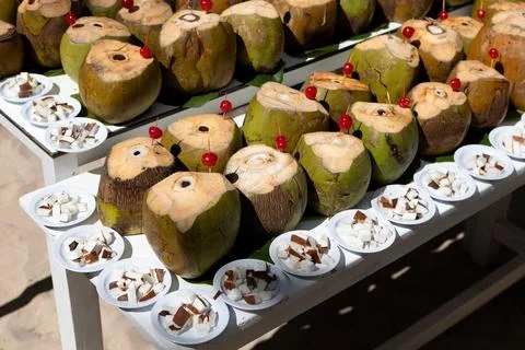 There are a lot of coconuts on the table with the top cut off.Beach holidays Fotos Stock