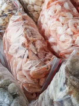 There are many large plastic bags with frozen raw and boiled shrimp on the .. Stock Photos