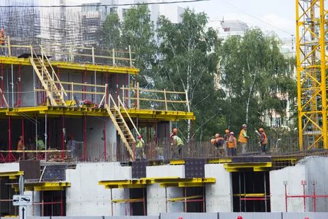 There are many workers working at the construction site. Workers on the const Stock Photos