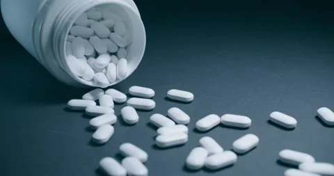 There are scattered white capsules from an open bottle nearby Vídeo Stock 302901952