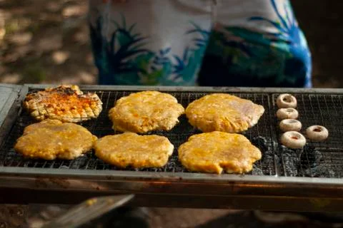 There are six half baked round burgers with some mushroom slices are getting  Stock Photos
