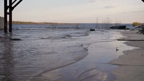 There are small waves on river bank.In the background is a boat. Summer evening. Stock Footage 130728739