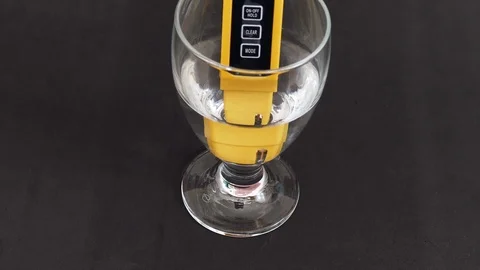 There are tds meter in the glass cup, the water hardness is measured, Stock Footage 104569414