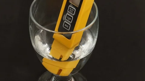 There are tds meter in the glass cup, the water hardness is measured, Stock Footage 104569955