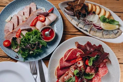 There are three plate of different dishes on the wooden table of the restau.. Foto stock