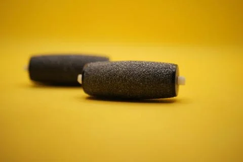 There are two black rollers that are currently positioned on a yellow surface Stock Photos