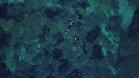There are two free divers in the crystal clear water, in the aerial footage on a Stock Footage 199414765
