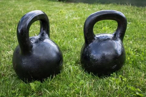 There are two large black heavy weights on the lawn Stock Photos