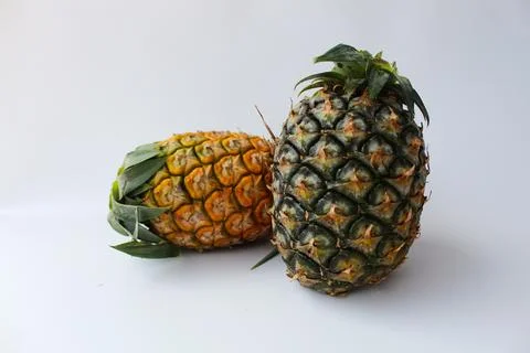 There are two pineapples on a white background with different colors Stock Photos